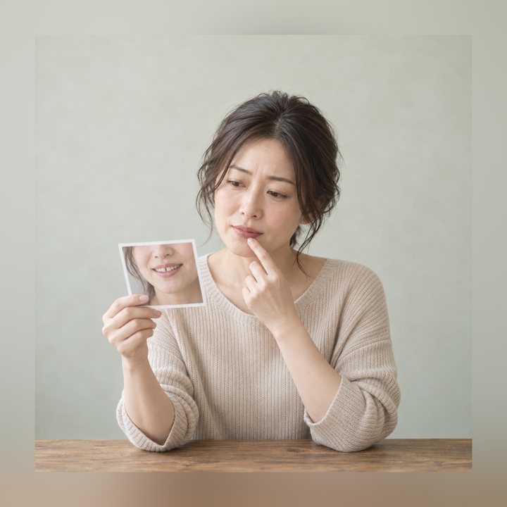 写真を見ながら歯の形とすき間を気にしている女性