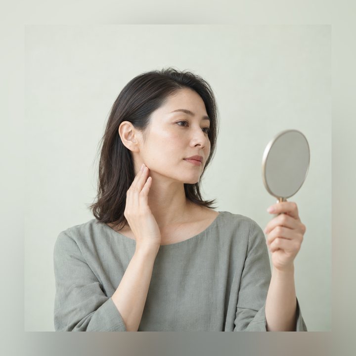 手鏡で横顔と歯並びを確かめている女性
